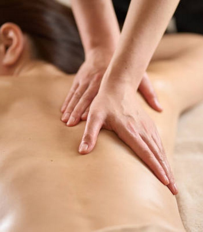 Woman receiving back massage at beauty salon